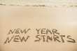 © anastasiapelikh - New Year New Starts text written on the sand