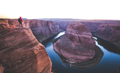 Wall Mural - Hiker overlooking Horseshoe Bend at sunset, Arizona, USA