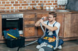 © LIGHTFIELD STUDIOS - young repairman in protective glasses checking broken vacuum cleaner