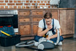 © LIGHTFIELD STUDIOS - young repairman in protective glasses looking at broken vacuum cleaner