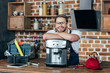 © LIGHTFIELD STUDIOS - handsome young repairman leaning at coffee machine and smiling at camera