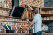 © LIGHTFIELD STUDIOS - young man in eyeglasses measuring kitchen hood with tape