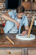 © LIGHTFIELD STUDIOS - handsome young man repairing stool with screwdriver