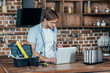 © LIGHTFIELD STUDIOS - young man in eyeglasses using laptop while repairing toaster at home