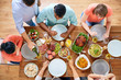 © Syda Productions - group of people eating at table with food