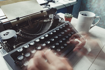 Writer typing with retro writing machine. View from above.