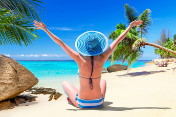 Wall Mural - Beautiful woman in blue hat on the tropical beach