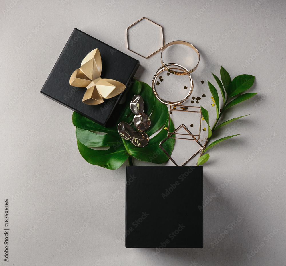 Opened gift box with handmade toy and streamers on color background, top view