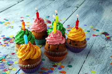 Tasty cupcakes on wooden background. Birthday cupcake in rainbow colors