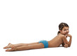 Cute boy in swimming trunks lies on the floor on his stomach. White background.