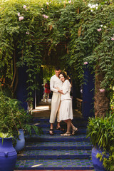 Wall Mural - Dreamy couple dressed in white closes walks around African city Marrakesh in a sunny evening