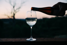 Man Pouring Wine In A Glass At Sunset