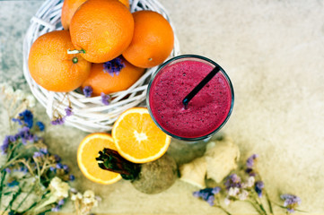 top view mixed fresh juice of orange, ginger and beetroot on stone background