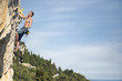 © Jovana Milanko/Stocksy - Free climber lead climbing vertical rock wall next to the sea
