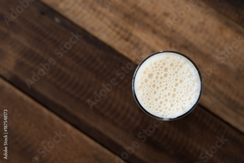Plakat mleko w szklance na drewnianym stole tło. szklanka mleka krowiego. zdrowy napój koncepcja