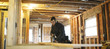 © Rob and Julia Campbell/Stocksy - Panoramic of young carpenter using skill saw inside