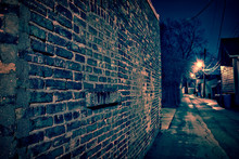 Vintage Brick Wall In A Dark, Gritty And Wet Chicago Alley At Night After Rain.