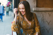 © Lauren Naefe/Stocksy - Young woman sitting at cafe and laughing