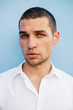© Nabi Tang/Stocksy - Handsome young man portrait on blue wall