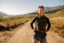 Smiling Young Woman Hiking With Backpack