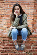 © Guille Faingold/Stocksy - Beautiful long-haired girl looking at camera with hand at face.