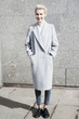 © Lyuba Burakova/Stocksy - Stylish woman standing against concrete wall
