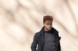 © Fjello/Stocksy - Young black man standing against a brown wall.