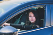 © kosim - Confident woman driving dark car