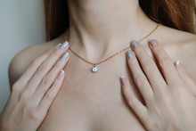 A Woman With A French Manicure Holding A Gold Chain In The Shape Of A Gemstone On His Neck. Advertising Jewelry.