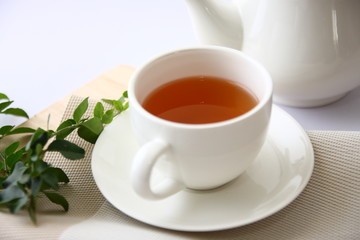 Tea in a white glass with leaves.