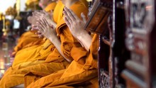 Many Monks Are Sitting Side By Side And Chanting