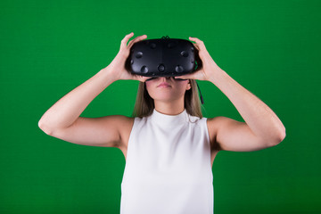 attractive woman wearing virtual reality headset in green screen studio