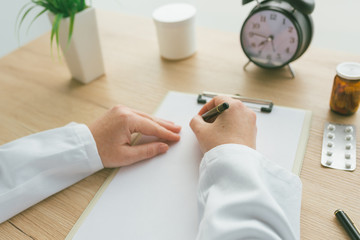 Sticker - Female doctor writing notes on clipboard paper during medical exam