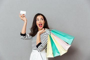 Canvas Print - Portrait of an excited woman showing credit card