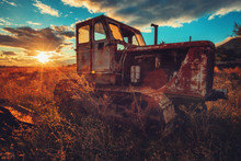 HDR Image Of Old Rusty Tractor In A Field. Sunset Shot