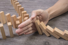Hand Stopping Wooden Block Domino. Concept Prevent And Solution.