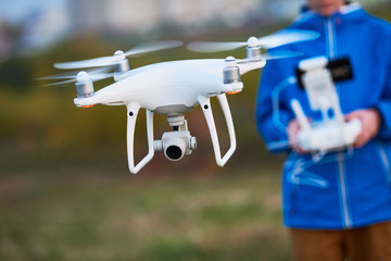 Wall Mural - young man operating of flying drone at sunset
