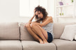 © Prostock-studio - Sad african-american woman on couch at home