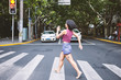 © Connect Images - Woman marching across pedestrian crossing, Shanghai French Concession, Shanghai, China