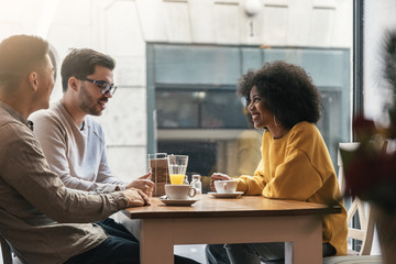 Group of happy friends chatting in the coffee shop.