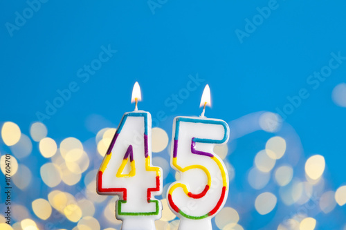 Photographie Number 45 birthday celebration candle against a bright lights and blue backgroun