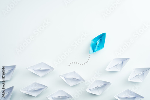 Fotomural Business concept as a group of paper ship in one direction and with one individu