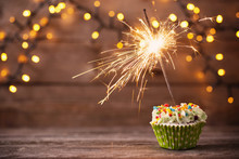 Cupcake With Sparkler On Old Wooden Background