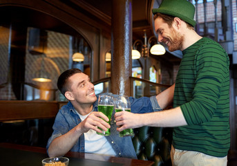 male friends drinking green beer at bar or pub