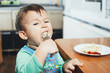 © komokvm - A hungry child is eating dumplings in the kitchen