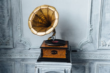 Old Record Player Against Ancient Wooden Wall. Antique Gramophone With Retro Plate Produces Pleasant Sounds Or Music. Stereo System. Revolution And Sound Technology Concept