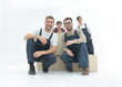 © ASDF - Smiling young delivery men holding stack of boxes. Isolated on w
