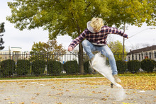 Man With Powder Paint Skateboarding At Park During Autumn