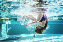 Full Length Of Girl Swimming Underwater In Pool