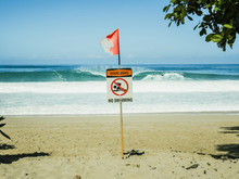 No Swimming Sign With Flag At Beach